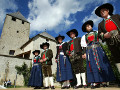 Ladini in abito tradizionale e sullo sfondo il castello di San Martino in Badia (foto www.altabadia.org)