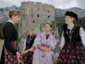 ragazze in abito tradizionale ladino - sullo sfondo l'"Andraz Museum"